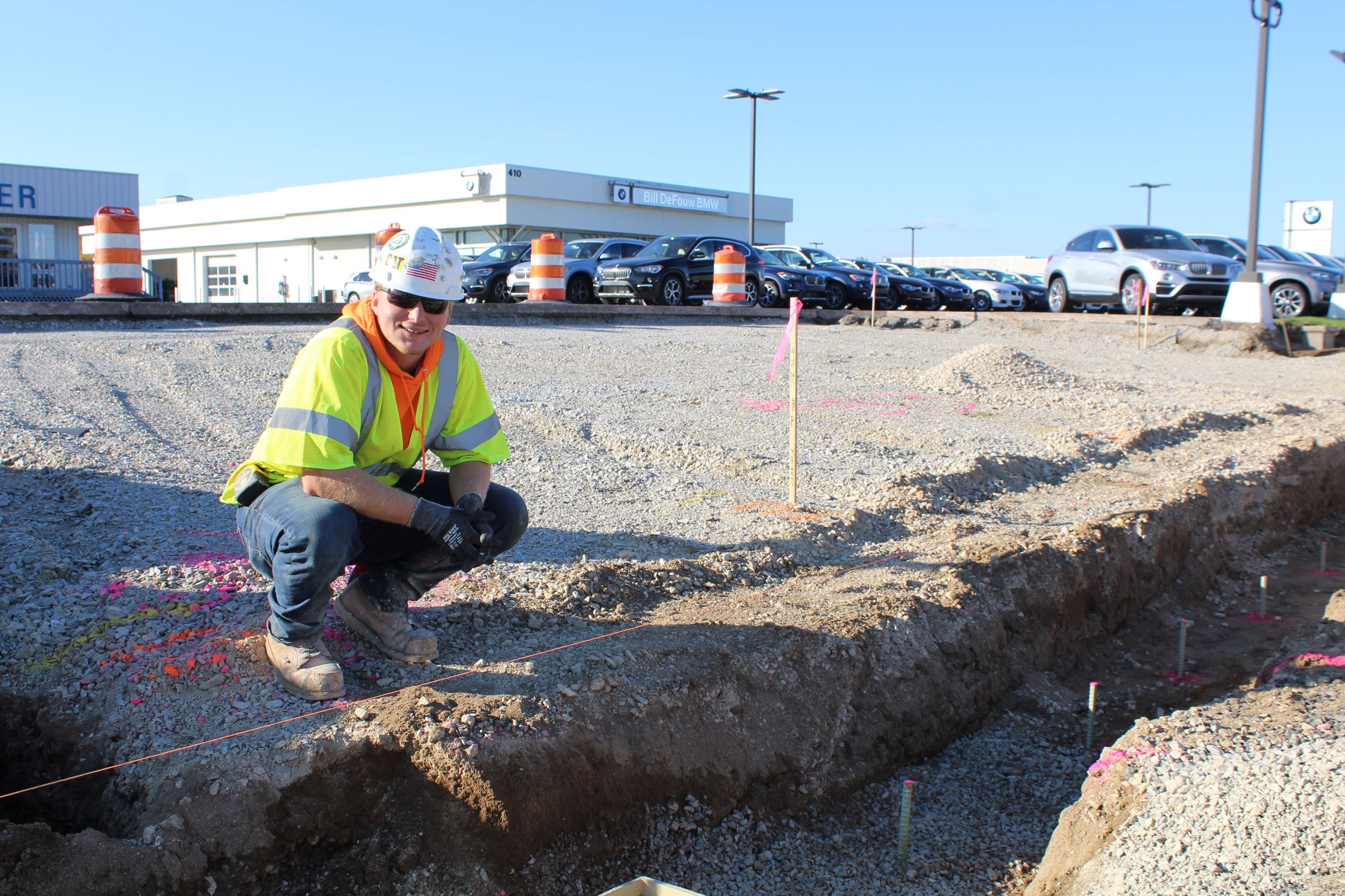A construction worker inspecting a drainage trench on Sagamore Parkway